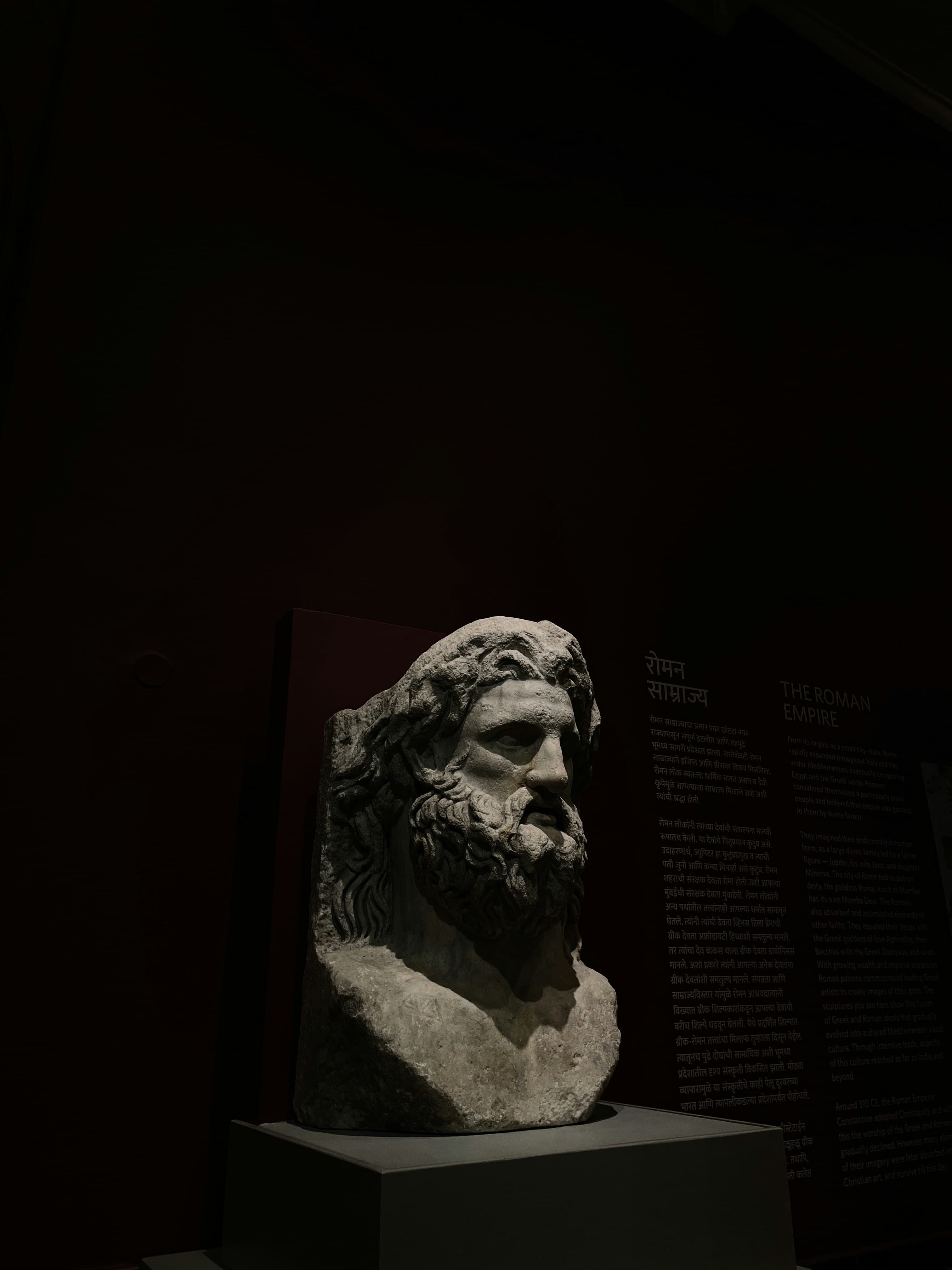 Classical bust lit in a dark museum setting